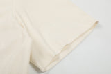 DAXUEN Asymmetrical collar short-sleeve top in cream and black