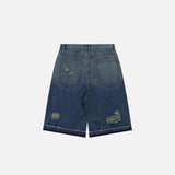 Back view of the blue Y2k Ripped Washed Jorts in a gray background