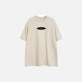 Front view of the beige Patchwork Embroidered Eye T-Shirt in a gray background