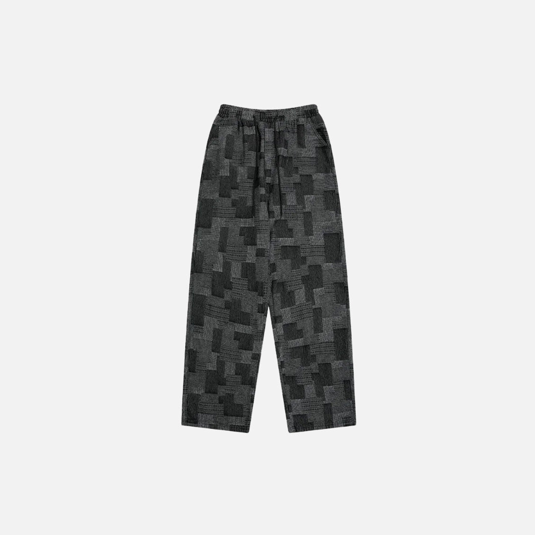 Front view of the black Patchwork Textured Jeans in a gray background