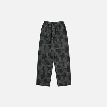 Front view of the black Patchwork Textured Jeans in a gray background