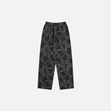 Front view of the black Patchwork Textured Jeans in a gray background