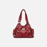 Front view of the burgundy Utility Wanderer Handbag in a gray background