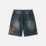 Back view of the blue Vintage Rip Patch Denim Shorts in a gray background