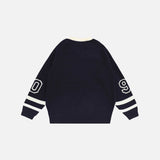 Back view of the blue Y2K Victory Varsity Sweater in a gray background