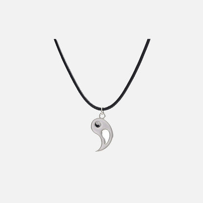 Front view of the Yin-Yang Puzzle Pendant Necklace in a gray background