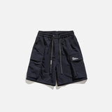 Front view of the navy Essential Utility Cargo Shorts in a gray background