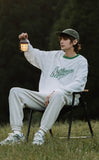 A guy wearing Michigan sweatshirt and setting on a chair