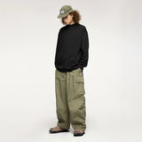Moel wearing the black Oversized Luxe T-Shirt in a gray background