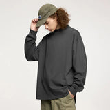 Moel wearing the dark gray Oversized Luxe T-Shirt in a gray background