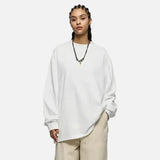 Moel wearing the white Oversized Luxe T-Shirt in a gray background