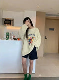 Model earng the apricot Cue Break Graphic Sweater