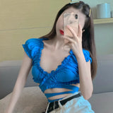 Model wearing the blue Ruffled Cut-Out Wrap Top