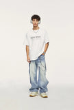 Model wearing the blue Baggy Washed Denim Jeans in a gray background 