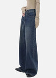 Model wearing the blue Retro Dark Washed Jeans in a gray background