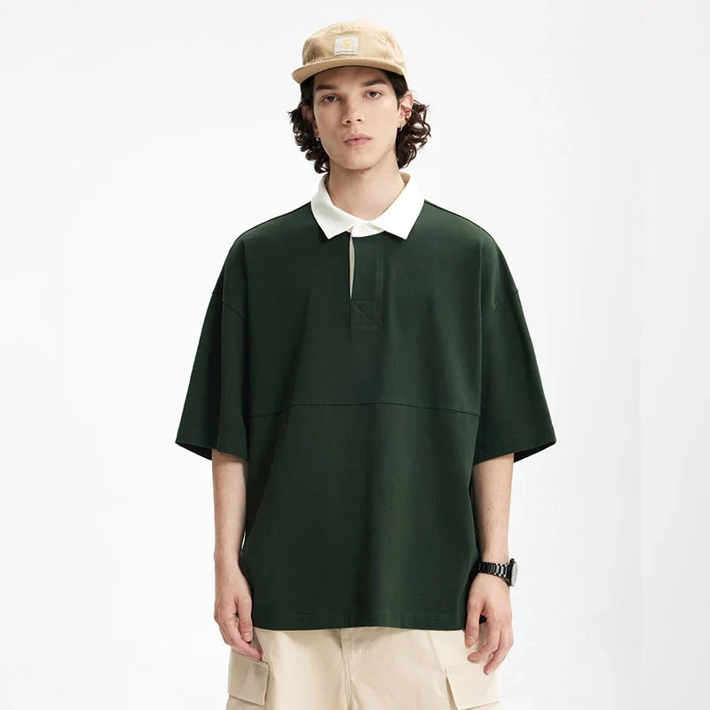 Model wearing the dark green Placket Polo T-Shirt in a gray background