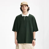 Model wearing the dark green Placket Polo T-Shirt in a gray background