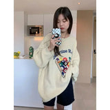 Model earng the apricot Cue Break Graphic Sweater