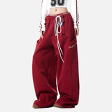 Red baggy pants with white drawstring on a white background