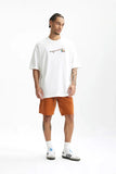Model wearing the white Nature's Real T-Shirt in a gray background