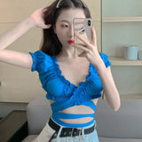 Model wearing the white Ruffled Cut-Out Wrap Top