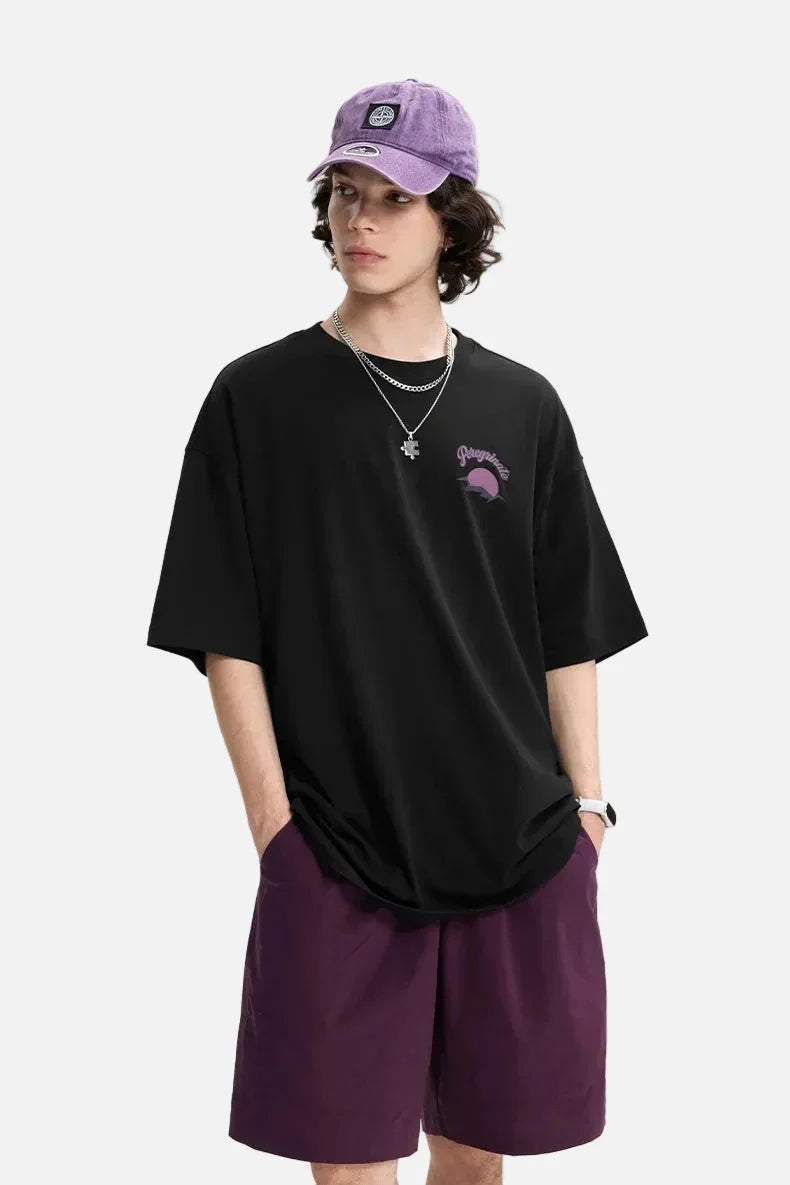 Model wearing the black Epic Voyage T-Shirt in a gray background