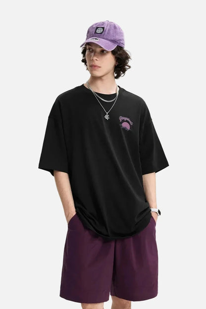 Model wearing the black Epic Voyage T-Shirt in a gray background