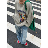 Model earng the gray Cue Break Graphic Sweater