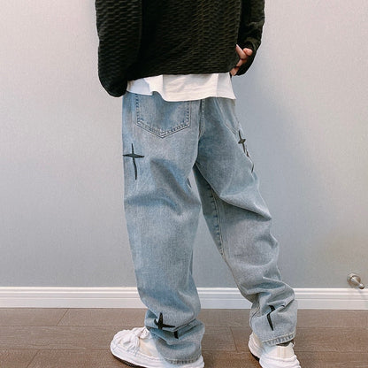 Black textured sweater, white shirt, light blue jeans with crosses, white sneakers, wooden background.