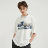 Model wearing Japanese Great Wave Graphic T-Shirt in a gray background 