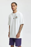 Moel wearing the white The Unity T-Shirt in a gray background