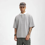 Model wearing the gray Placket Polo T-Shirt in a gray background
