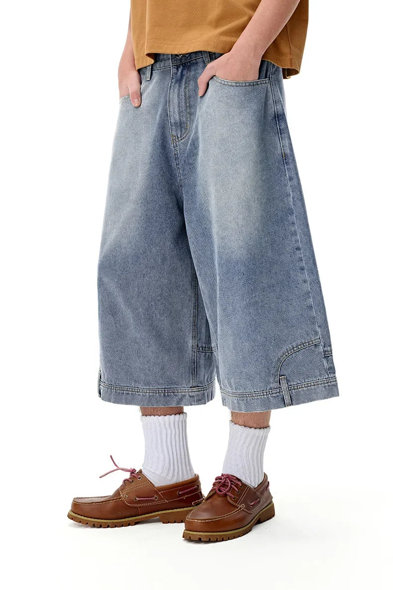 Model wearng the blue Washed Denim Pants in a gray background