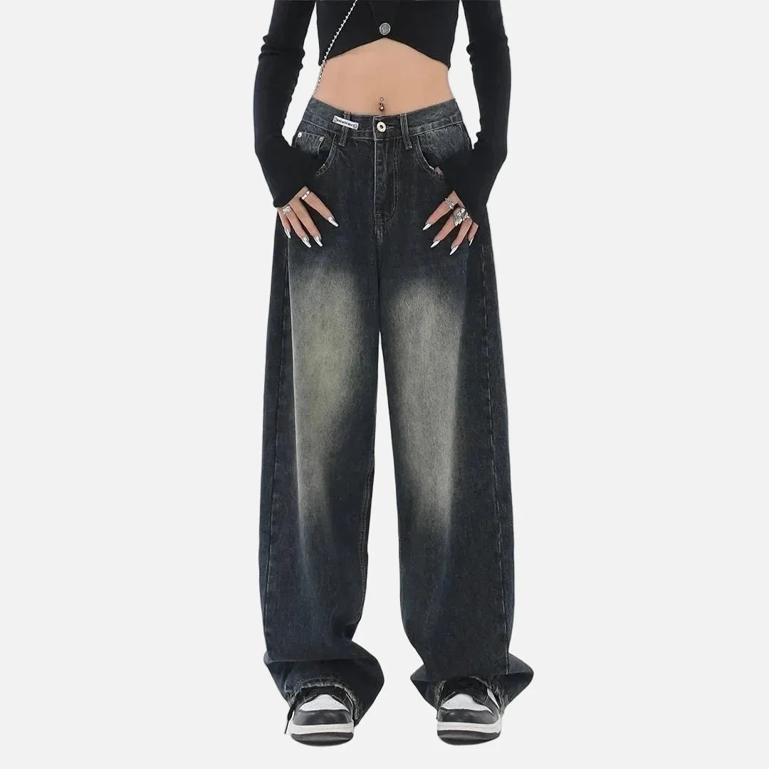 Model wearing the deep blue Vintage Washed Denim Jeans in a gray background