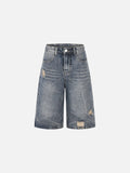 Faded blue vintage wash denim shorts with distressed rips and abstract white contrast stitching