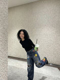 DAXUEN Baggy blue denim jeans with graphic patches — model photo