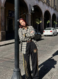 DAXUEN black wide-leg track pants with embroidered crest — model photo