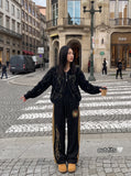 DAXUEN black wide-leg track pants with embroidered crest — model photo