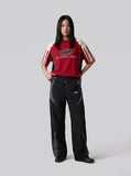 DAXUEN black wide-leg track pants with dark grey curved panels — model photo