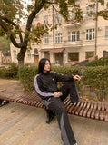 DAXUEN black wide-leg track pants with dark grey curved panels — model photo