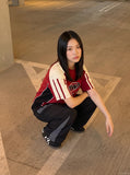DAXUEN black wide-leg track pants with dark grey curved panels — model photo