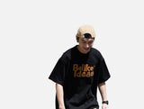 DAXUEN black oversized bold brown-orange wordmark graphic t-shirt