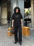 DAXUEN Bold oversized t-shirt with graphic embroidery and studs — model photo