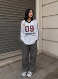 DAXUEN white oversized plaid '09' graphic v-neck jersey top — model photo