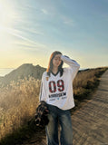DAXUEN white oversized plaid '09' graphic v-neck jersey top — model photo