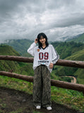 DAXUEN white oversized plaid '09' graphic v-neck jersey top — model photo