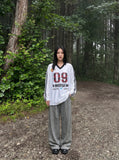DAXUEN white oversized plaid '09' graphic v-neck jersey top — model photo