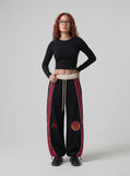 DAXUEN black oversized bold-red-side-panel sweatpants — model photo