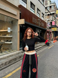 DAXUEN black oversized bold-red-side-panel sweatpants — model photo