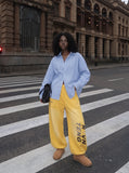 DAXUEN yellow and dark blue studded graphic wide-leg pants — model photo